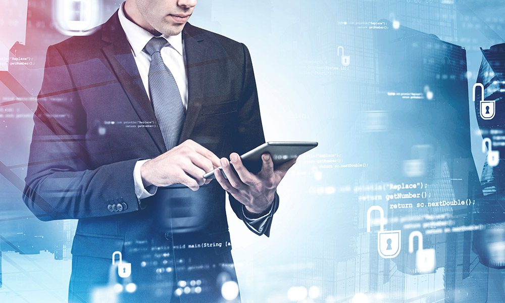 What is cyber liability insurance and why do I need it? - Man Standing and Using a Tablet With Technology Visuals in the Foreground