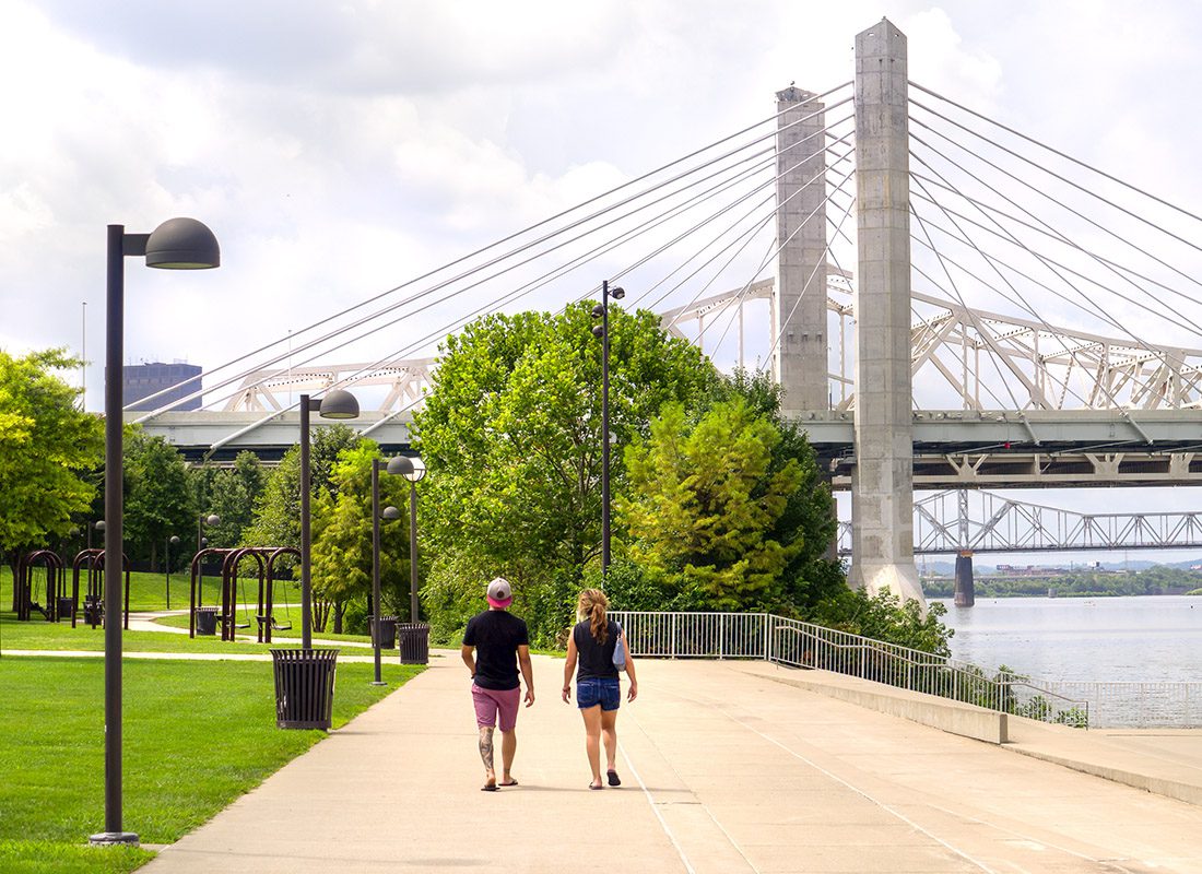 About Our Agency - People Walk on a Path Along an Urban Waterfront Park in Louisville Kentucky